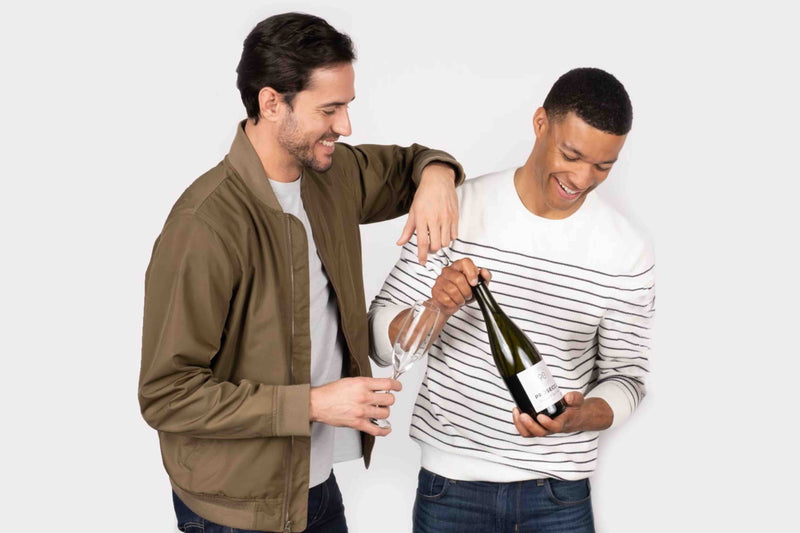 Two men pouring white wine