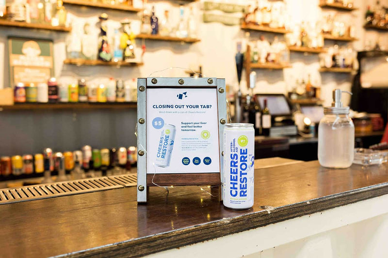 Cheers restore can product on a bar