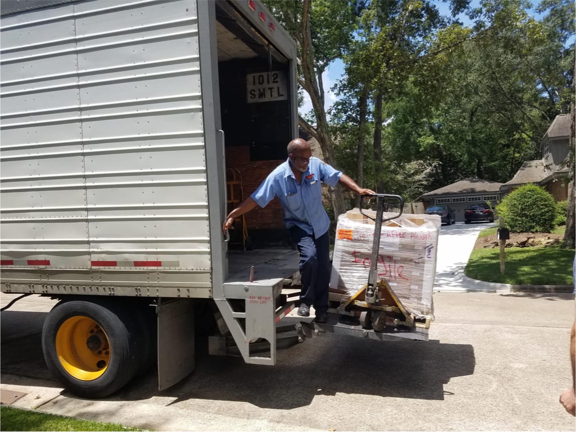 Man unloading a truck with boxes on a residential street