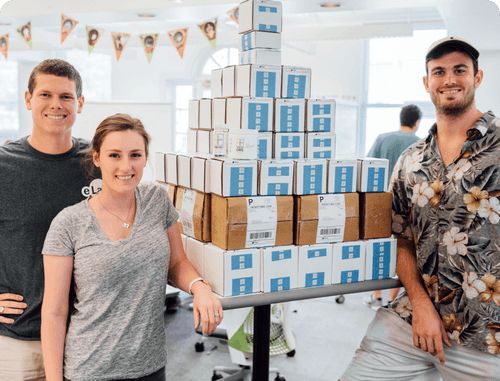 Cheers team around a table of packaged products